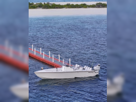 A sleek speedboat is seen approaching a red dock, surrounded by clear blue waters — perfect for a day of adventure on the water.