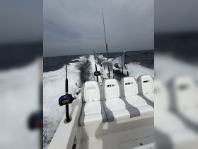Interior view of a sleek boat featuring comfortable seating and fishing gear, perfect for a day out on the water.