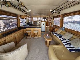 Interior view of a spacious boat cabin featuring comfortable seating and a well-equipped kitchen area, perfect for relaxing and entertaining while on the water.