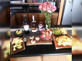 An inviting display of gourmet snacks and drinks, including wine, guacamole, and desserts, perfect for a luxurious onboard experience.