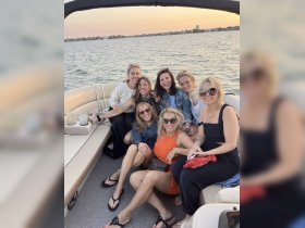 A lively group of friends enjoys a sunset gathering on a pontoon boat, celebrating with drinks and laughter — the perfect backdrop for unforgettable memories on the water.