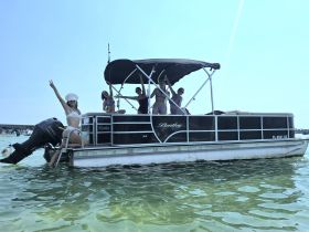 A lively group enjoys a fun day on a Bentley pontoon boat, showcasing the perfect atmosphere for summer parties and water activities.