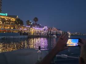 A guest captures the vibrant nightlife along the waterfront, featuring illuminated restaurants and a beach shuttle, creating a lively atmosphere perfect for evening outings.