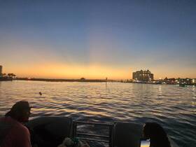 A stunning sunset view from a boat, with guests enjoying the serene waterfront atmosphere — perfect for evening cruises and relaxation.