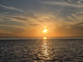 A stunning sunset over tranquil waters, creating a beautiful reflection — perfect for capturing serene moments on the water.