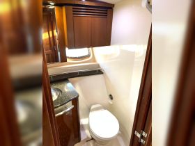 A clean and modern boat bathroom featuring a toilet and sink, showcasing the interior amenities available for guests on board.