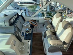 Interior view of a boat's helm and seating area, showcasing the modern design and comfortable layout, perfect for navigating the waters.