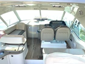 A spacious and well-appointed helm area inside the boat, featuring comfortable seating and modern controls, perfect for navigating the open waters.