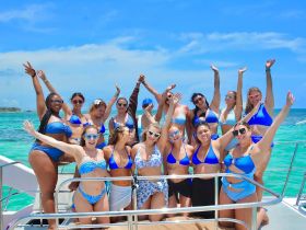 A vibrant group of friends celebrates aboard a boat, showcasing fun and camaraderie under the sun — perfect for bachelorette parties or summer getaways.