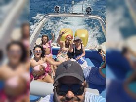 A joyful group enjoys a fun day on the water, capturing memories aboard a boat with smiles and celebrations. Perfect for group outings and adventures.