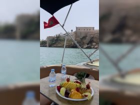 A beautifully arranged platter of fresh fruit and bottled water on a boat, perfect for enjoying a refreshing snack while taking in the scenic views.