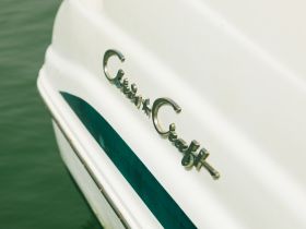 Close-up of the 'Chris Craft' nameplate on a boat, showcasing the elegant design and craftsmanship typical of this renowned brand.
