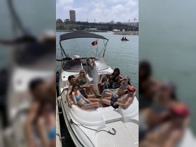 A lively group enjoys a sunny day on a boat, perfect for socializing and relaxation on the water.