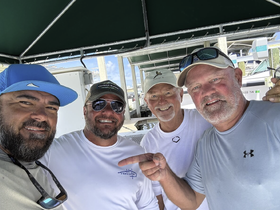 A group of friends poses for a cheerful selfie at the marina, capturing the excitement of their upcoming boating adventure.