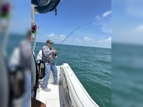 A fisherman reels in a catch while enjoying a day out on the open water — a perfect snapshot of fishing adventures at sea.