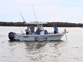 A group of friends celebrates a successful fishing trip aboard their boat, showcasing their catch while enjoying a day on the water.