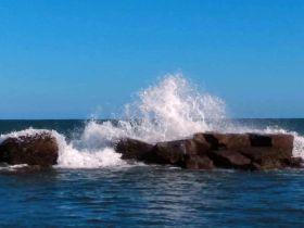 A dynamic shot capturing waves crashing against rocks in the ocean, showcasing the beauty of coastal scenery.
