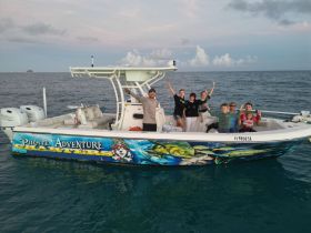 A joyful family poses aboard the 'Pirate Adventure' boat, celebrating their time on the water with smiles and excitement — perfect for family outings and adventure charters.