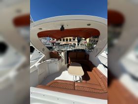 Interior view of a stylish boat lounge area featuring comfortable seating and a table, perfect for relaxing while enjoying the water.