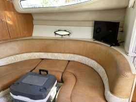 Cozy interior of a boat cabin featuring comfortable seating and a TV, perfect for relaxing during trips on the water.