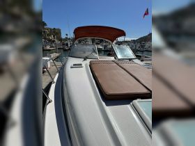 A close-up view of the deck of a yacht, showcasing its sleek design and comfortable seating area, perfect for relaxing on the water.