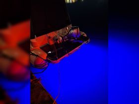 A close-up view of the back of a boat showcasing vibrant underwater lighting, creating a stunning ambiance for nighttime outings.