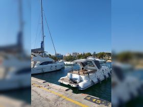 A sleek yacht docked at the marina, showcasing its elegant design against a clear blue sky — perfect for luxury boating experiences.