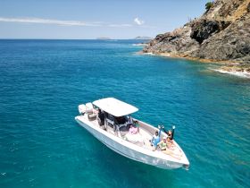 A lively group enjoys a day on the water aboard a boat, showcasing the perfect blend of fun and adventure in a stunning ocean setting.