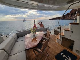 A man enjoys the serene sunset view from the deck of a yacht, showcasing the relaxing atmosphere of a boating experience.