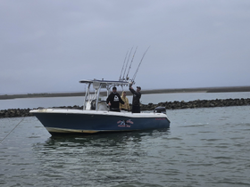 A group of friends enjoys a fishing trip on a boat, showcasing the excitement of a day on the water.