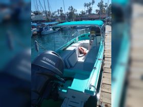 Interior view of a well-equipped boat featuring comfortable seating and a helm, perfect for a day on the water.