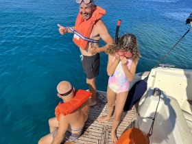 A family enjoys a snorkeling adventure on a boat, with smiles and excitement as they prepare to explore the vibrant underwater world.