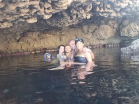A group of friends enjoys snorkeling in a stunning underwater cave, creating unforgettable memories in a unique aquatic environment.