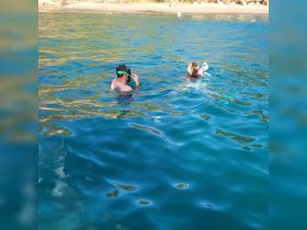 A couple enjoys snorkeling in crystal-clear waters, capturing the essence of a perfect beach day filled with adventure and exploration.