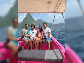 A joyful family enjoys a boat ride with stunning island scenery in the background, perfect for creating unforgettable memories on the water.