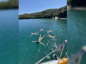 A group of friends enjoys a sunny day floating in the clear waters, creating a fun and relaxing atmosphere perfect for summer adventures.