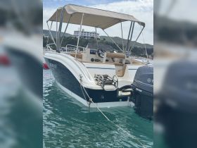 A sleek speedboat named 'KEVIN 03' anchored in clear waters, showcasing its stylish design and comfortable seating, perfect for a day on the water.