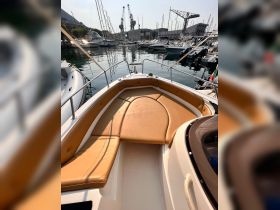 Interior view of a boat's seating area, showcasing comfortable cushions and a sleek design, perfect for relaxing on the water.