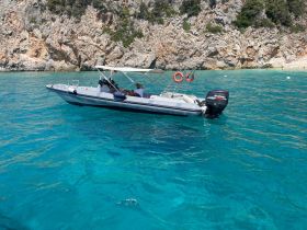 A sleek speedboat navigates through crystal-clear turquoise waters, showcasing the beauty of a coastal adventure.