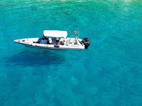 A boat navigates through stunning turquoise waters, showcasing a perfect day for adventure on the sea.