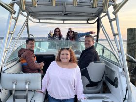 A lively group enjoys their time aboard a boat, celebrating with drinks and smiles against a scenic backdrop — perfect for memorable outings on the water.