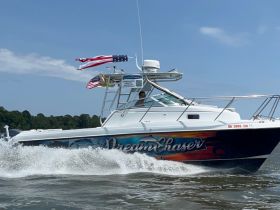 The 'Dream Chaser' speedboat glides through the water, showcasing its vibrant design and American flags, perfect for adventurous outings on the water.