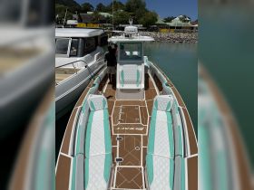 A stylish interior view of a modern boat showcasing comfortable seating and a helm area, perfect for a day on the water.