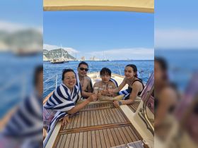A joyful group of friends celebrates with champagne on a yacht, enjoying the stunning coastal views — perfect for memorable gatherings on the water.