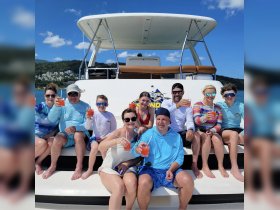 A cheerful group enjoys cocktails aboard a boat, celebrating together under the sun — perfect for family gatherings or festive outings on the water.