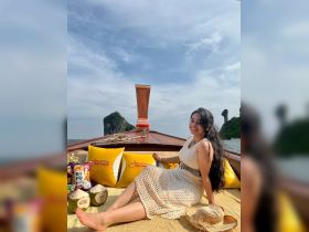 A woman enjoys a relaxing moment on a boat, surrounded by stunning scenery and refreshments, perfect for a day out on the water.