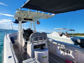 A view of the helm and seating area inside a boat, showcasing the control console and a glimpse of another boat in the background — perfect for those looking to explore the waters.