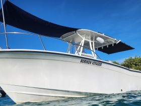 A striking view of the 'Boriken Voyager' speedboat, showcasing its sleek design against a clear blue sky — perfect for adventure on the water.