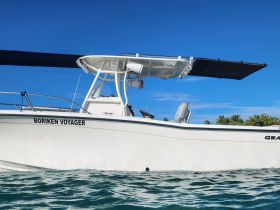 A sleek view of the 'Boriken Voyager' speedboat, showcasing its design against a clear blue sky and tranquil waters, perfect for adventurous outings.