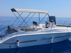 A sleek 23 Open boat glides through calm waters, showcasing its elegant design and perfect for a day out on the sea.
